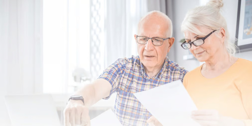 elderly couple looking at retirement paperwork